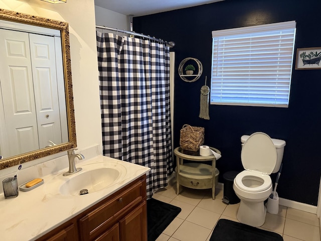 full bathroom featuring toilet, vanity, baseboards, and tile patterned floors