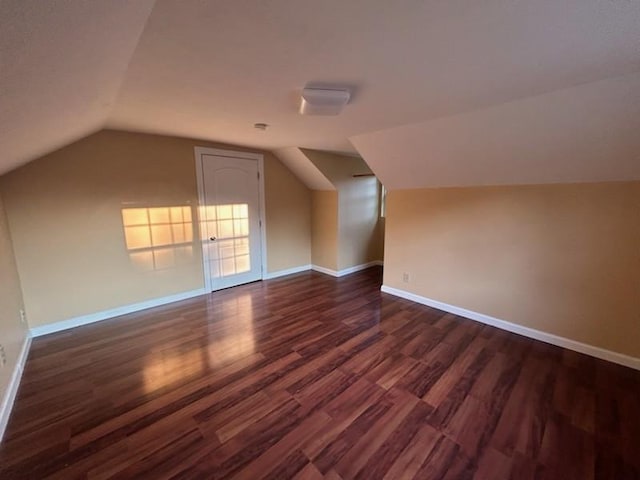 bonus room with vaulted ceiling, dark wood-type flooring, and baseboards