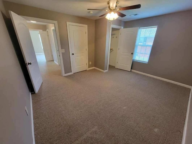 unfurnished bedroom featuring carpet floors, visible vents, ceiling fan, and baseboards