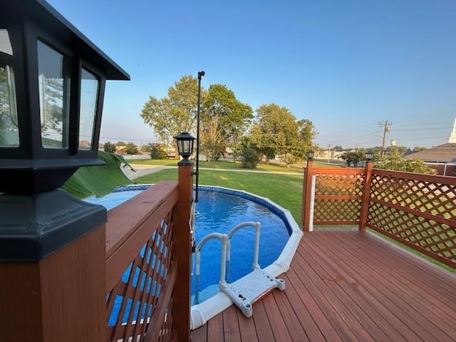 view of pool with a deck and a yard