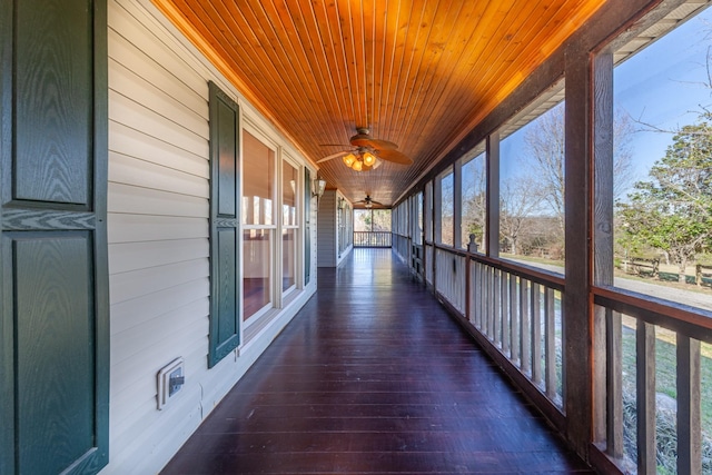 unfurnished sunroom featuring wooden ceiling and a ceiling fan