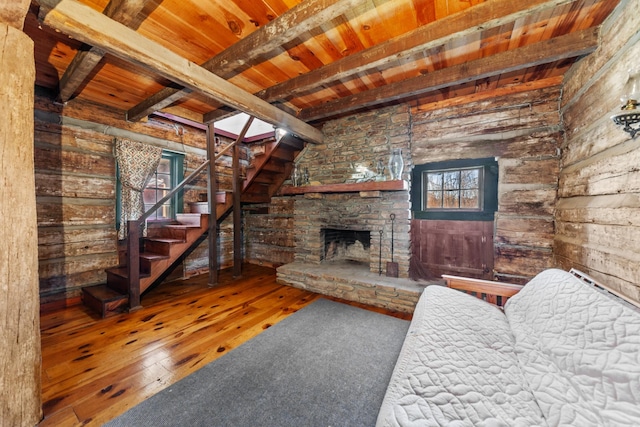 unfurnished living room featuring wood ceiling, wood-type flooring, stairs, a fireplace, and beam ceiling