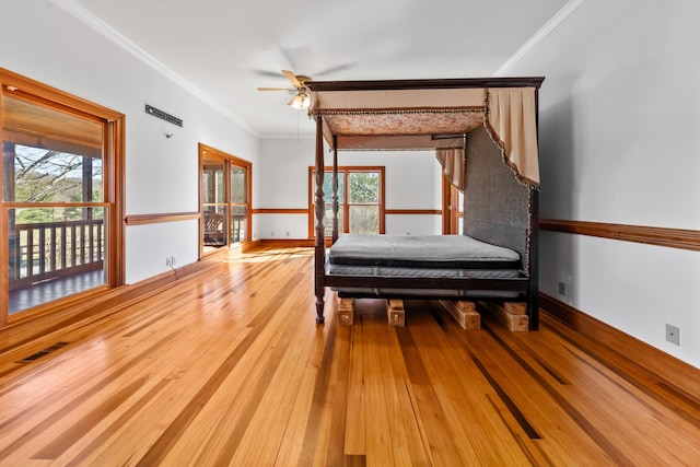 unfurnished bedroom featuring baseboards, ornamental molding, visible vents, and light wood-style floors