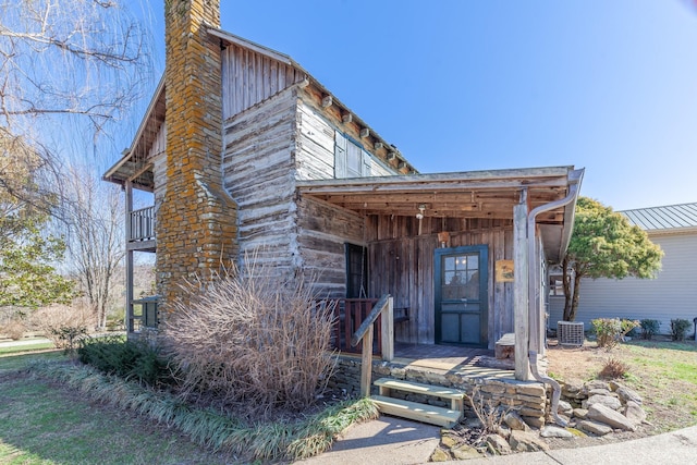 view of front of property featuring a chimney and a balcony