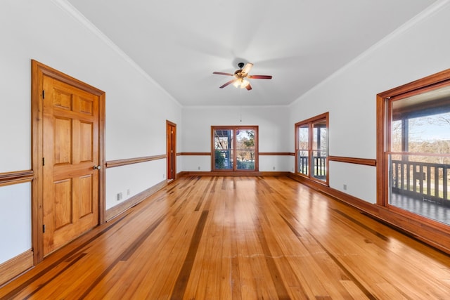 spare room featuring baseboards, ceiling fan, ornamental molding, and light wood-style floors