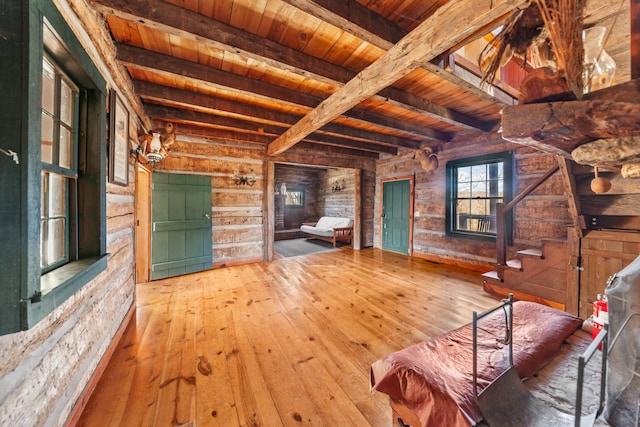 unfurnished living room featuring wood ceiling, beamed ceiling, stairway, and hardwood / wood-style floors