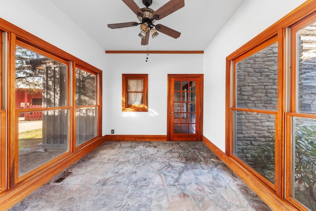 unfurnished sunroom featuring plenty of natural light, visible vents, and a ceiling fan