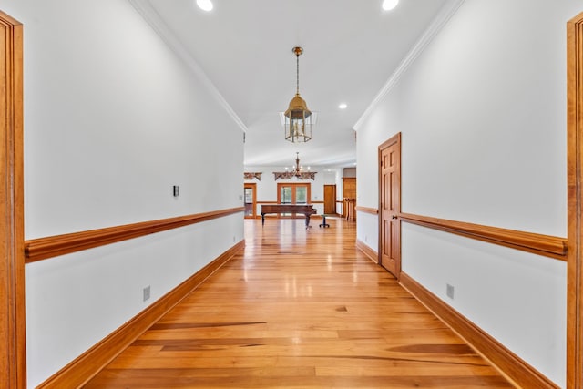 corridor with a notable chandelier, recessed lighting, baseboards, light wood-type flooring, and crown molding