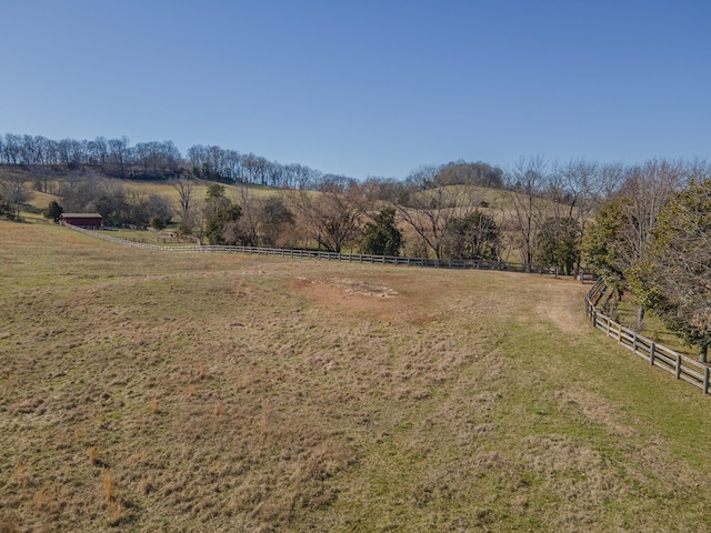 exterior space with fence and a rural view