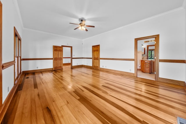 unfurnished room with ornamental molding, ceiling fan, light wood-style flooring, and baseboards