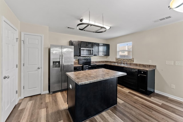 kitchen with black appliances, light wood finished floors, and visible vents