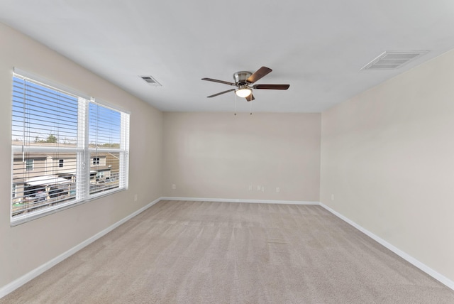 unfurnished room featuring light colored carpet, visible vents, and baseboards