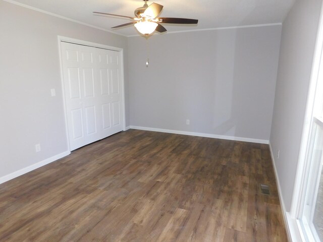 unfurnished bedroom featuring visible vents, baseboards, ornamental molding, wood finished floors, and a closet