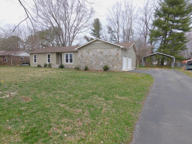 ranch-style home featuring aphalt driveway, an attached garage, stone siding, and a front yard