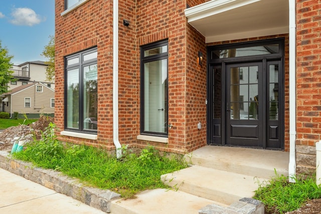 doorway to property with brick siding