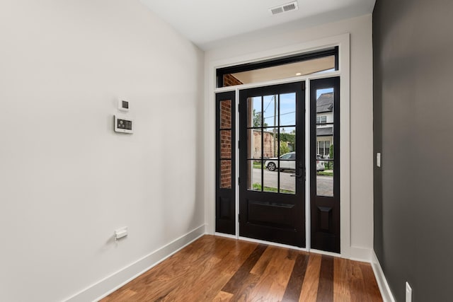 entrance foyer featuring baseboards, visible vents, and dark wood-type flooring