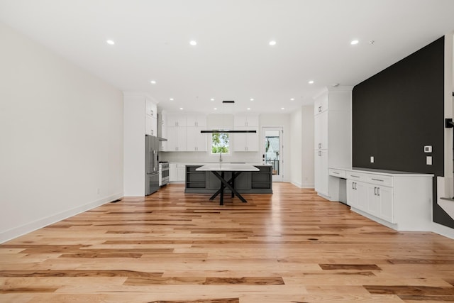 living room with baseboards, recessed lighting, and light wood-style floors