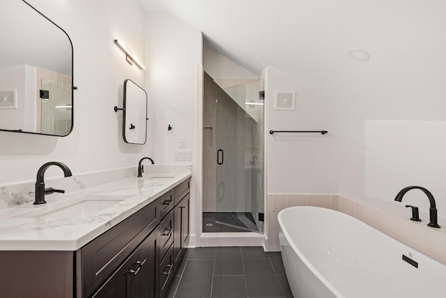 bathroom featuring a stall shower, a soaking tub, a sink, and tile patterned floors