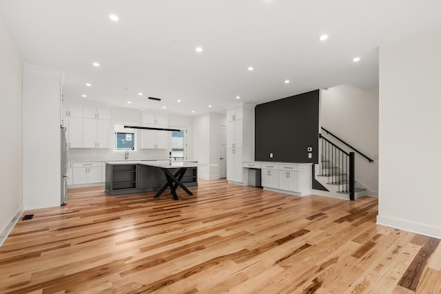 living area with stairs, light wood finished floors, baseboards, and recessed lighting