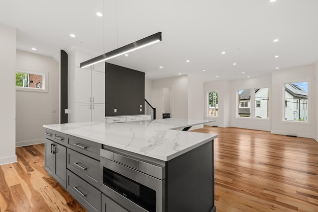 kitchen with gray cabinetry, recessed lighting, white cabinetry, a large island, and light wood finished floors