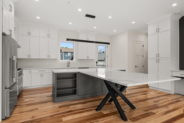 kitchen with tasteful backsplash, recessed lighting, light wood-style flooring, appliances with stainless steel finishes, and white cabinetry