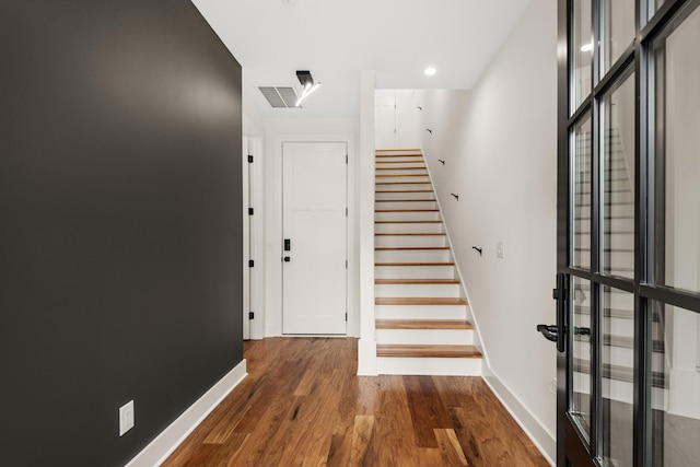 foyer featuring stairs, wood finished floors, visible vents, and baseboards