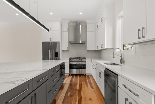 kitchen featuring beverage cooler, a sink, white cabinets, appliances with stainless steel finishes, and wall chimney exhaust hood