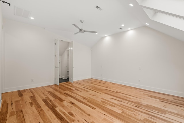 bonus room featuring vaulted ceiling with skylight, light wood finished floors, and visible vents