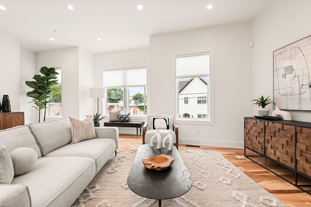 living room with light wood-style floors, recessed lighting, visible vents, and baseboards