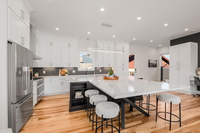 kitchen with stainless steel appliances, tasteful backsplash, a spacious island, and recessed lighting