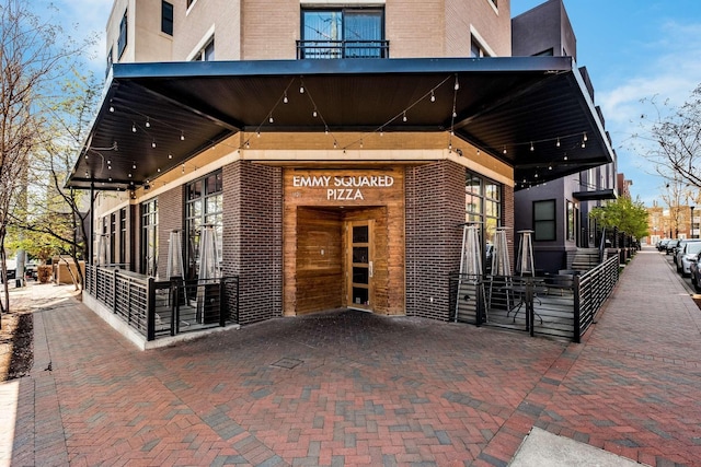 entrance to property featuring brick siding