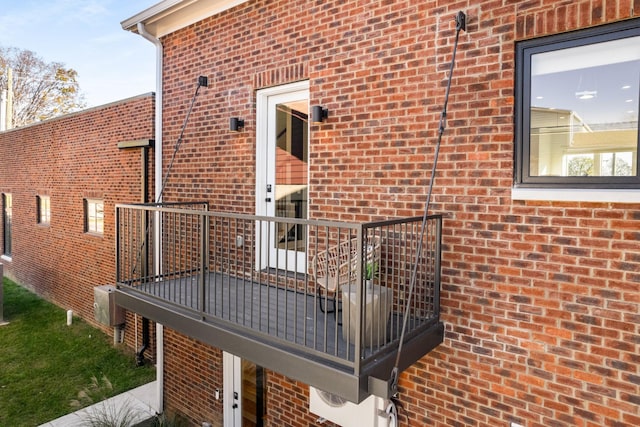 exterior space featuring a balcony and brick siding