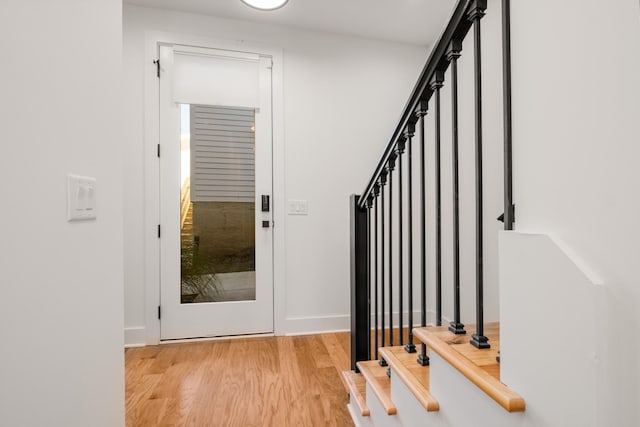 foyer with stairs, light wood-type flooring, and baseboards