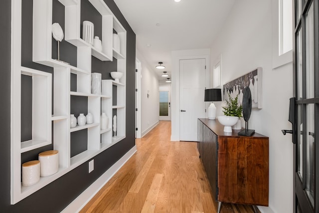 hallway with baseboards and light wood-style floors