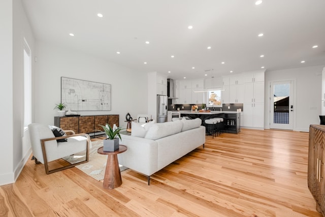 living area with recessed lighting and light wood-style flooring