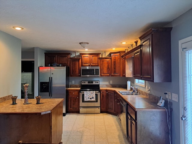 kitchen featuring light tile patterned floors, recessed lighting, stainless steel appliances, a sink, and light countertops