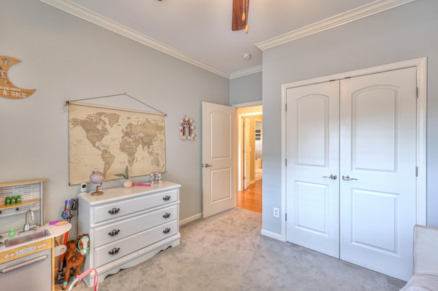 bedroom featuring ceiling fan, light carpet, baseboards, a closet, and crown molding