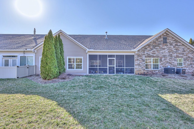 back of house with cooling unit, a sunroom, a lawn, and fence