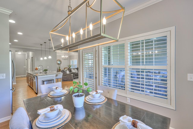 dining area with ornamental molding, recessed lighting, a chandelier, and light wood-style flooring