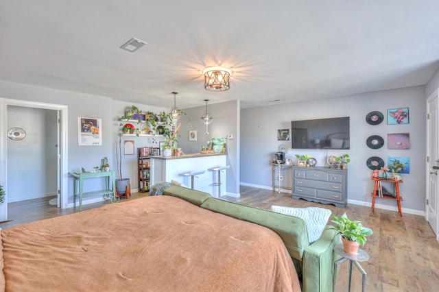 bedroom with visible vents, baseboards, and wood finished floors