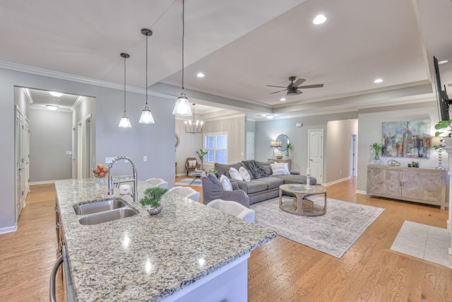 kitchen featuring light wood-style floors, baseboards, and a sink