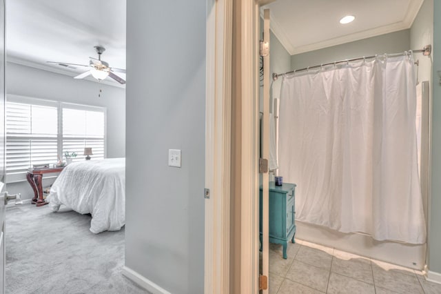 ensuite bathroom with baseboards, ornamental molding, ceiling fan, and tile patterned floors