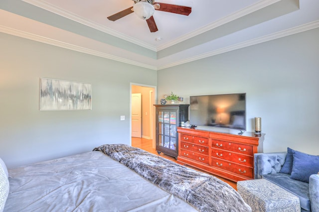 bedroom featuring wood finished floors, a raised ceiling, a ceiling fan, and crown molding