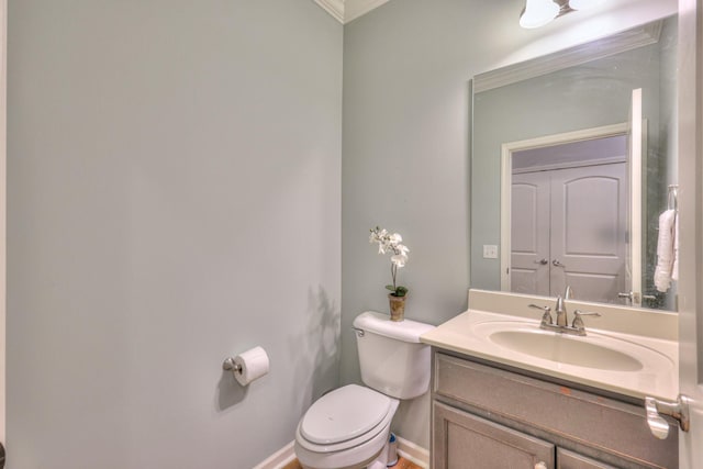 half bath featuring baseboards, vanity, and toilet