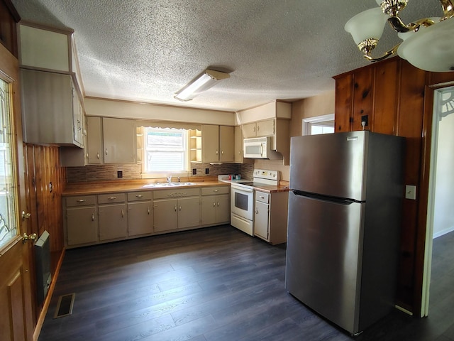 kitchen featuring dark wood-style floors, white appliances, visible vents, and tasteful backsplash