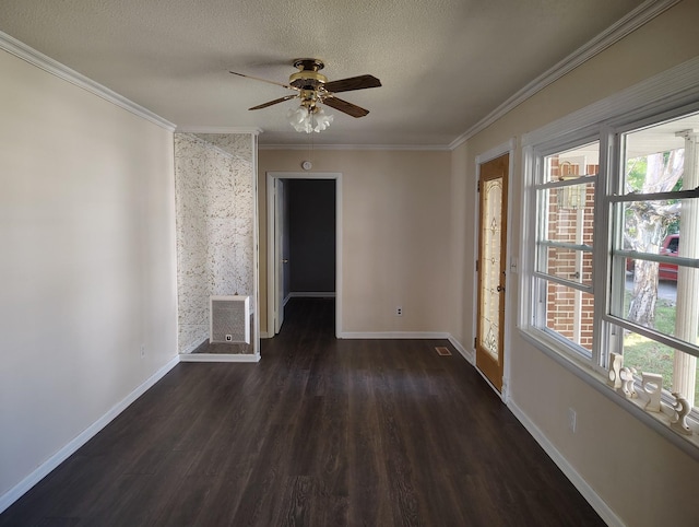 spare room with baseboards, dark wood finished floors, and crown molding