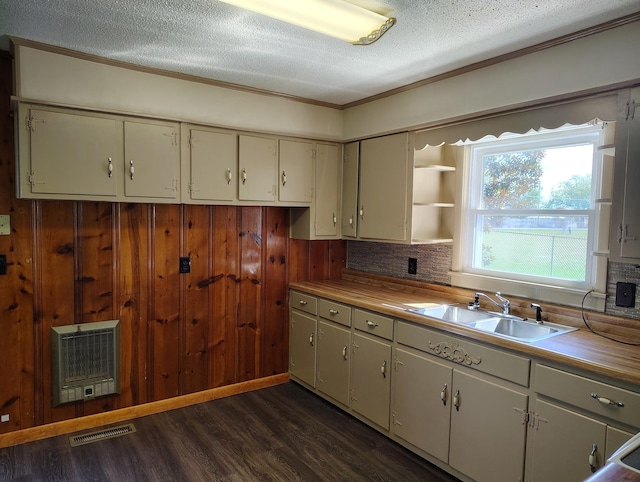 kitchen featuring dark wood-style floors, heating unit, visible vents, a sink, and a textured ceiling