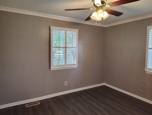 empty room featuring dark wood-type flooring, visible vents, ornamental molding, and baseboards