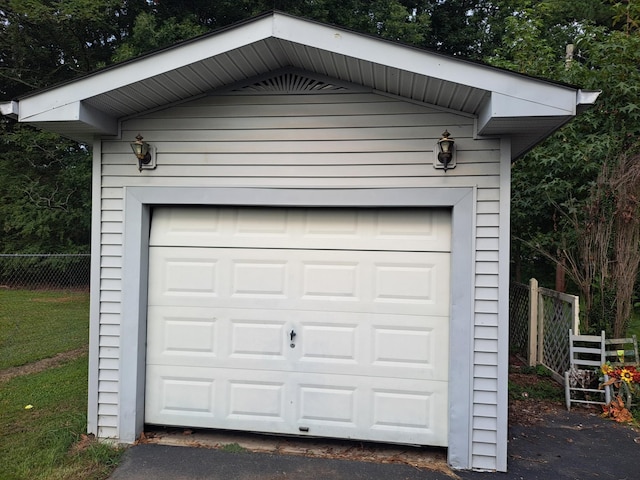 detached garage featuring fence