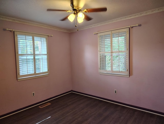 empty room with a ceiling fan, wood finished floors, visible vents, and baseboards